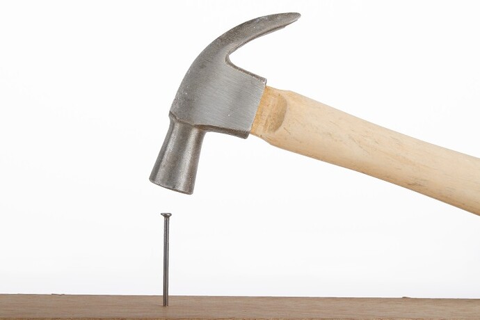 hammer-hitting-nail-on-head-1150200356